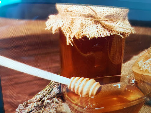 Şık bir kavanozda süzme bal ve kasede bal kaşığı ile sunulan taze bal görseli; petek bal mı süzme bal mı sorusuna yanıt veren kapak fotoğrafı